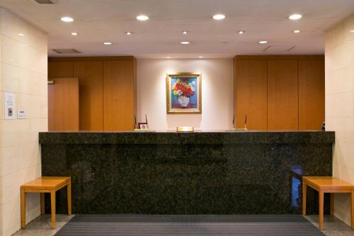 a waiting room with a counter and two benches at Smile Hotel Shizuoka in Shizuoka