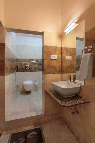 a bathroom with a sink and a shower and a toilet at Mimosa Udaipur in Udaipur