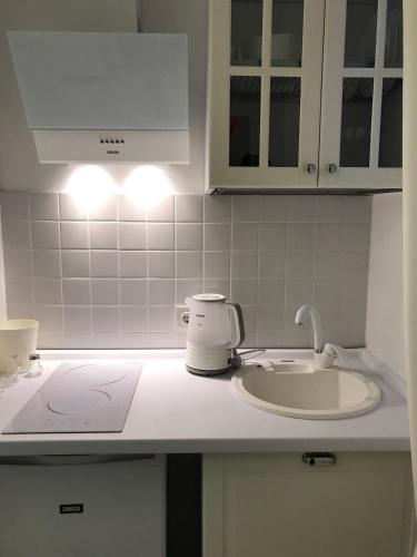 a kitchen with a sink and a counter top with lights at Apart Hotel Quartet in Odesa
