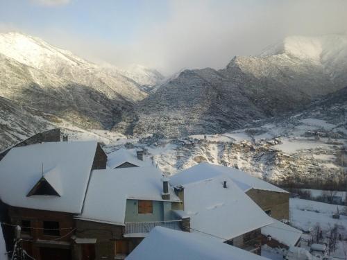 a snow covered mountain range with houses and snow covered roofs at Lo Paller de Roc in Montescladó