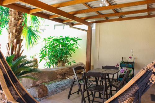 a patio with a table and chairs on a porch at Recanto Dos Coqueiros in Florianópolis