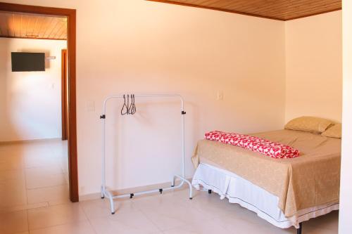 a bedroom with a bed with a red blanket on it at Recanto Dos Coqueiros in Florianópolis