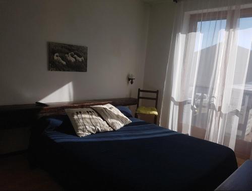 - une chambre avec un lit doté d'un oreiller et d'une fenêtre dans l'établissement Auberge MAS DE LAYALLE, à Saintes-Maries-de-la-Mer