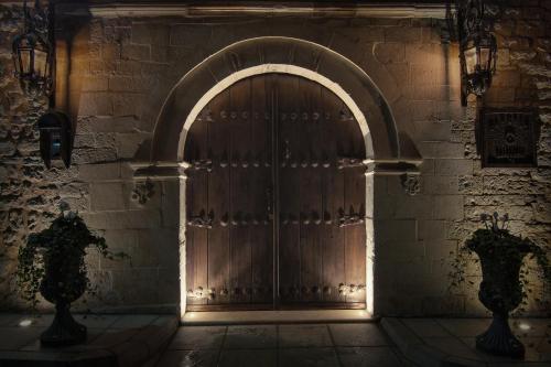 a wooden door in a brick wall with a light shining through at KAMARES Historic Boutique Hotel & Spa in Ioannina