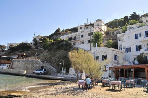 a group of people sitting on a beach near the water at Marina Hotel in Agios Kirykos