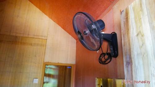 a fan hanging on the wall of a room at Pinthu Home Stay in Sigiriya