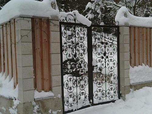 a metal gate with snow on top of it at Altes Forsthaus am Bach in Altaussee