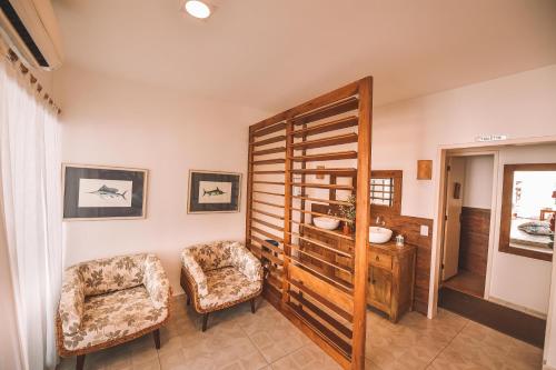 a living room with a chair and a mirror at Pousada da Prainha in Arraial do Cabo