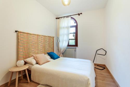 a bedroom with a white bed and a window at Villa Diana Tarzo in Tarzo