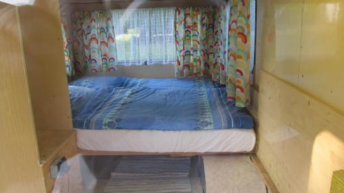 ein kleines Bett in einem kleinen Zimmer mit Fenster in der Unterkunft Am Wolfsbach 5 in Weitenhagen