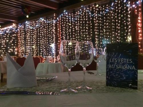 two wine glasses sitting on a table with lights at Hotel Jardin Savana Dakar in Dakar