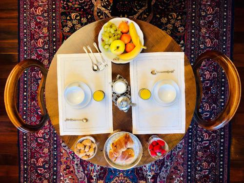 uma mesa com um prato de comida e uma taça de fruta em Opera Deluxe em Ravenna