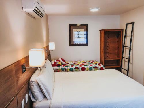 a bedroom with two beds and a mirror at Pousada da Prainha in Arraial do Cabo