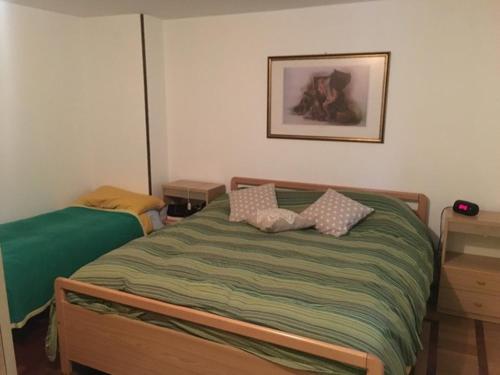 een slaapkamer met een bed en een foto aan de muur bij Appartamento Cretaz 2 in Valtournenche