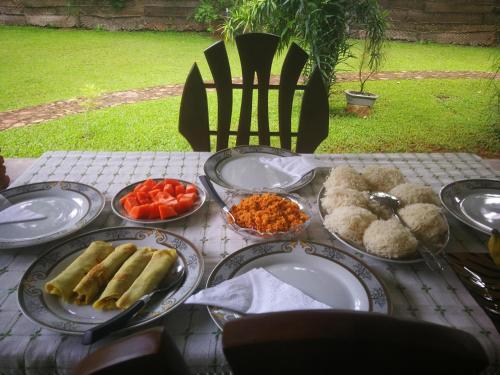 a table with plates of food on top of it at Green Cottage in Anuradhapura