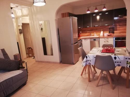 une cuisine et une salle à manger avec une table et un réfrigérateur dans l'établissement Appartement Le Cernuschi Rdc, à Menton