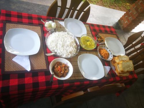 a table with plates and bowls of food and rice at Green Cottage in Anuradhapura