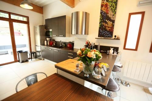 une cuisine avec une table avec un vase de fleurs dessus dans l'établissement Royal - Liza's house, à Saint-Germain-en-Laye