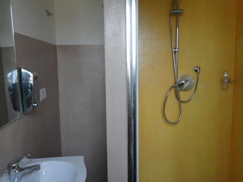 a bathroom with a shower, sink, and mirror at Pavia Ostello in Pavia