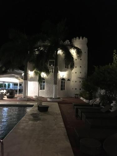a white building with a clock tower at night at Le Castel Blanc Hotel Boutique in San Andrés