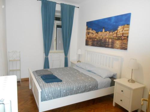 sypialnia z łóżkiem i obrazem na ścianie w obiekcie Andrea e Valentina w Trieście