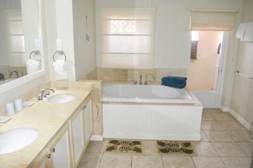 un bagno con 2 lavandini e una vasca di The Harbour a Rodney Bay Village