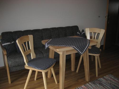 a table and four chairs and a couch at Gästehaus Proisl in Lenggries