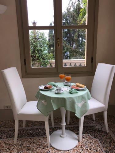 a table with two chairs and two glasses of wine at B&B Villa Costanza in Blevio