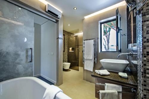 a bathroom with a tub and a toilet and a sink at Four Seasons Country Club in Quinta do Lago