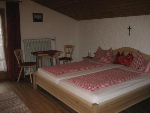 a bedroom with a bed and a table and chairs at Gästehaus Proisl in Lenggries