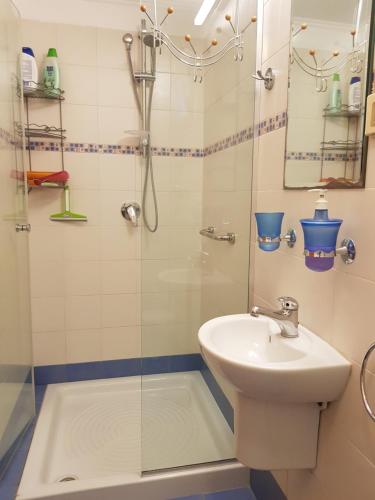 a bathroom with a shower and a sink at Bright, inviting, unique architecture, great location flat in Bet Shemesh