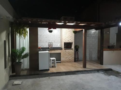 a kitchen with a white refrigerator in a room at Kitinetes - com WiFi - frigobar - TV- Cozinha completa in Rio das Ostras