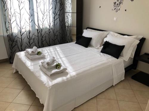 a large white bed with two towels on it at Paralio Astros in Paralio Astros