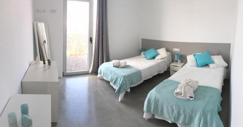 een slaapkamer met 2 bedden en blauwe kussens bij Turquesa 2 Fuerteventura in Lajares