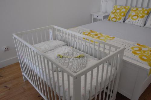 a white crib with a white and yellow crib at Ocean View double Suite in Paço de Arcos