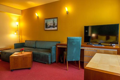 a living room with a couch and a flat screen tv at Penzion u Pejtrika in Mengusovce