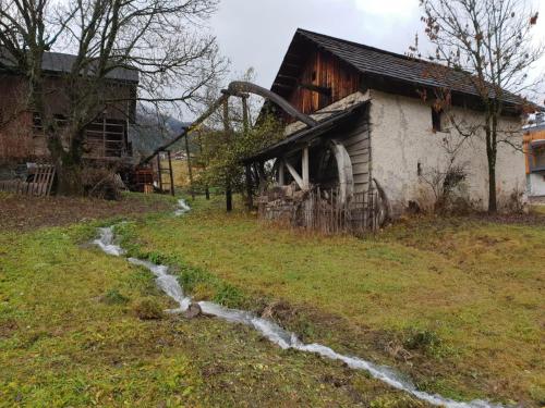 an old house with a water ditch in front of it at Chalet Morin in San Martino in Badia