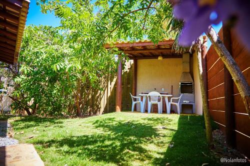 a patio with a table and chairs in a yard at Pousada Watu Kerere in Praia do Rosa
