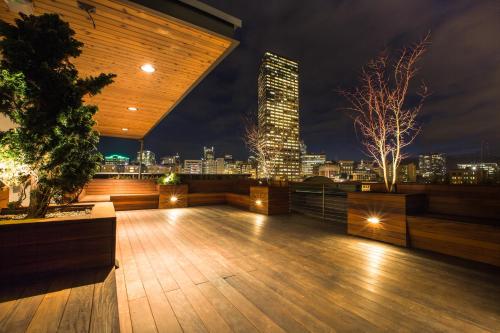 a rooftop deck with a view of a city at night at The Society Hotel in Portland