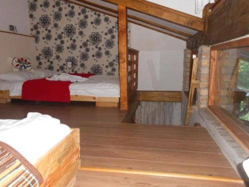 a bedroom with two beds and a wooden floor at Apartments Borove Noci in Vrdnik