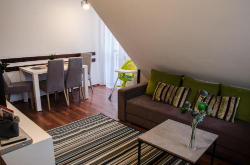 a living room with a couch and a table at Apartamenty Rohatka in Zakopane