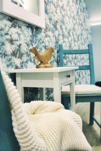 a toy bird sitting on a table next to a chair at Pod Wodospadem in Szczyrk
