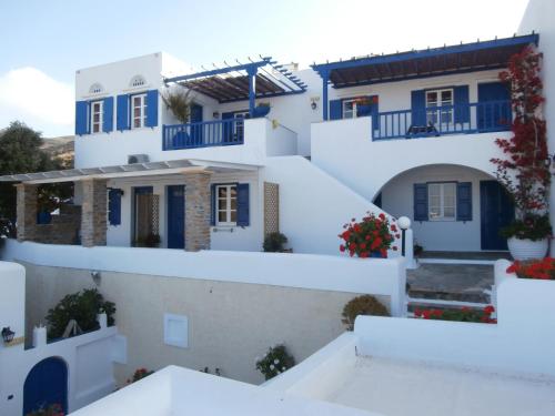 una fila de casas blancas con puertas y ventanas azules en Galini Bungalows en Kionia
