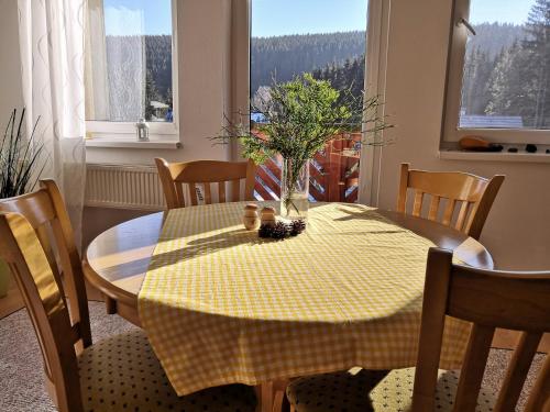 a dining room table with a yellow checkered table cloth at Apartmán BORKA in Donovaly