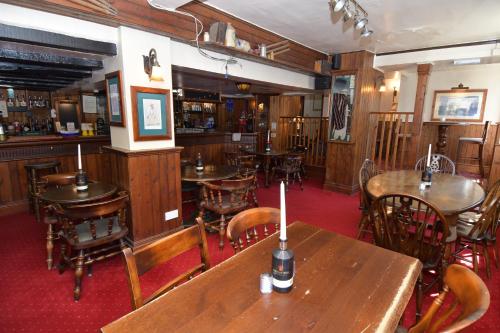 a restaurant with wooden tables and chairs and a bar at The Inn On The Green in Ockley