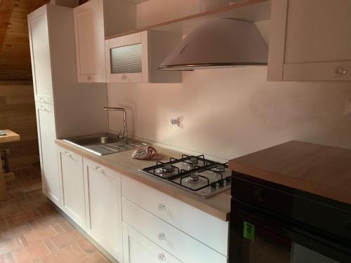 馬庫尼亞加的住宿－appartamento Joder，厨房配有白色橱柜和炉灶烤箱。