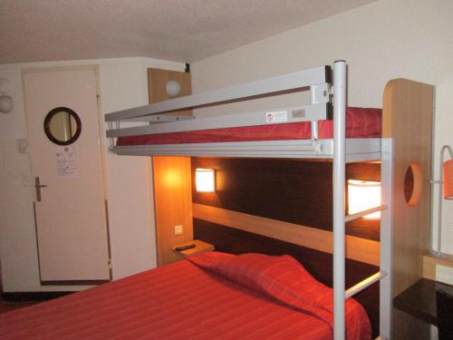 a bunk bed with a red blanket on top of it at Premiere Classe Avignon Le Pontet in Le Pontet