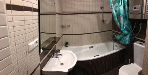 a bathroom with a sink and a bath tub at Megre Sweet Home in Gudauri