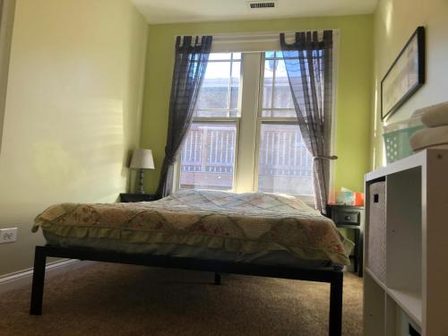 a bedroom with a bed in front of a window at The Greenleaf House in Chicago