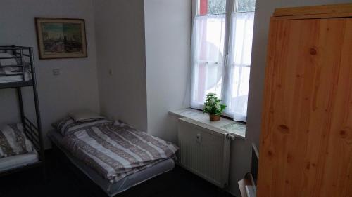 a small bedroom with a bed and a window at Pension na hranici in Železná Ruda